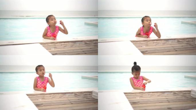一个可爱的快乐的年轻女婴婴儿在游泳池边放松，天空。