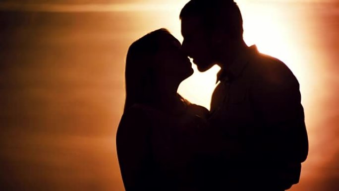 日落时接吻的夫妇