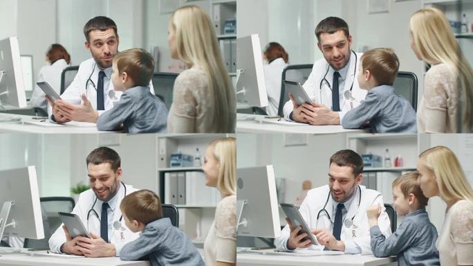 男医生咨询小男孩和他的母亲。他在平板电脑上向他们展示了一些东西。