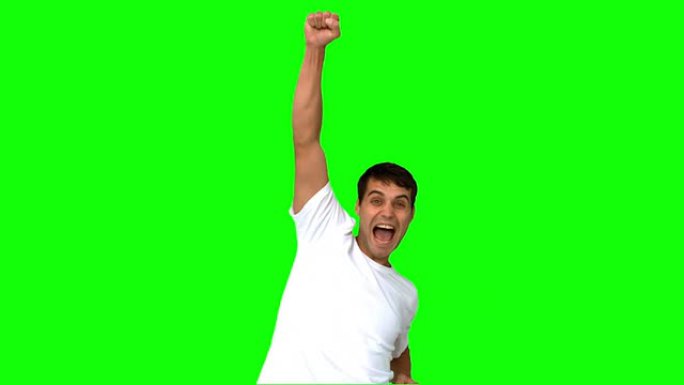 快乐男人在绿色屏幕上举起手臂