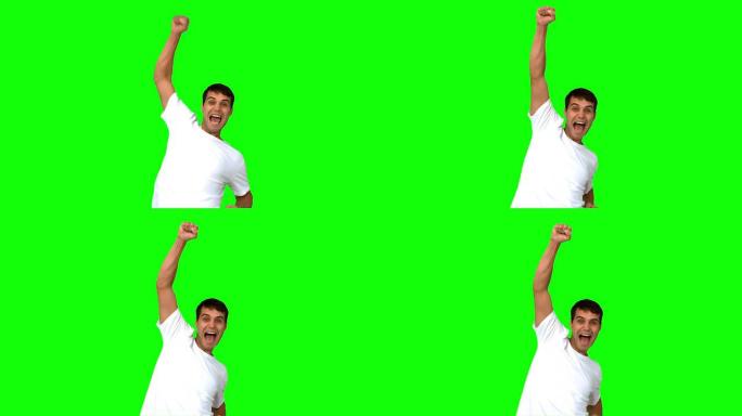 快乐男人在绿色屏幕上举起手臂