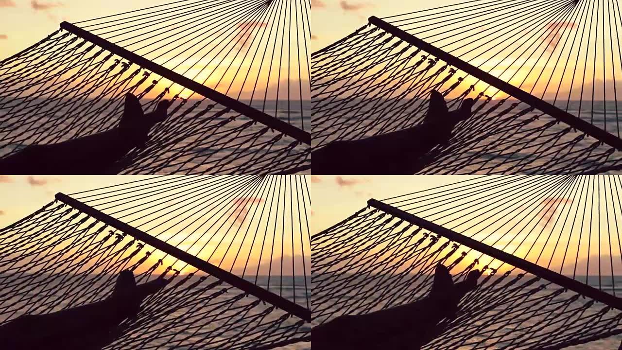 双脚在日落时分在大海之间摆动。温暖的Instagram色调