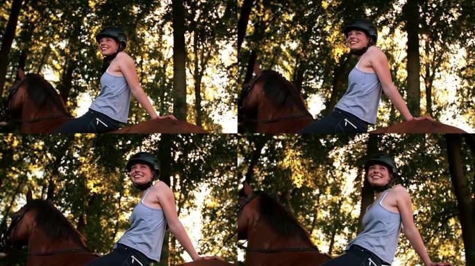 女孩骑着马沿着阳光普照的公园小巷