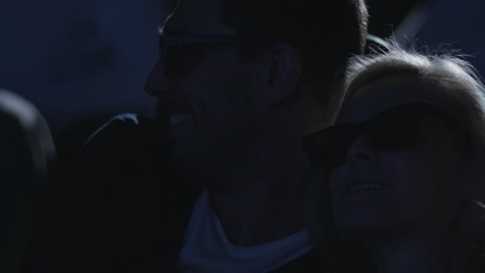 一对夫妇在电影院观看5d电影放映时互相拥抱的特写镜头。