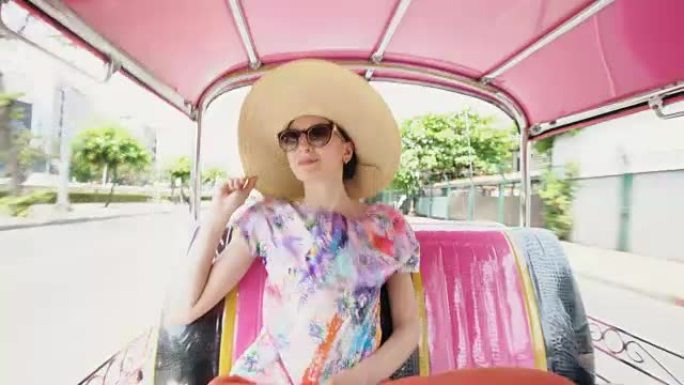 年轻漂亮的旅游女人戴着帽子坐在泰国曼谷传统的泰国公共汽车松托上