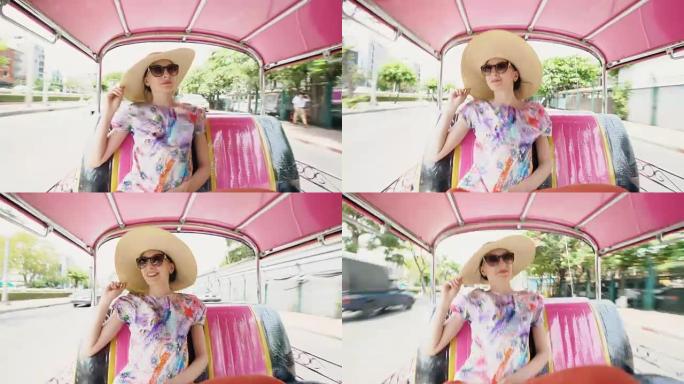 年轻漂亮的旅游女人戴着帽子坐在泰国曼谷传统的泰国公共汽车松托上