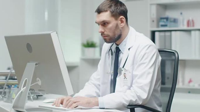 男医生正在办公桌前工作。他使用个人电脑和查阅文档。