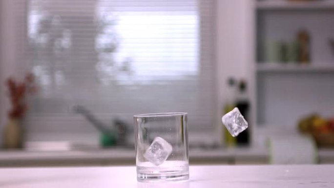 两个冰块落在一个空玻璃杯中