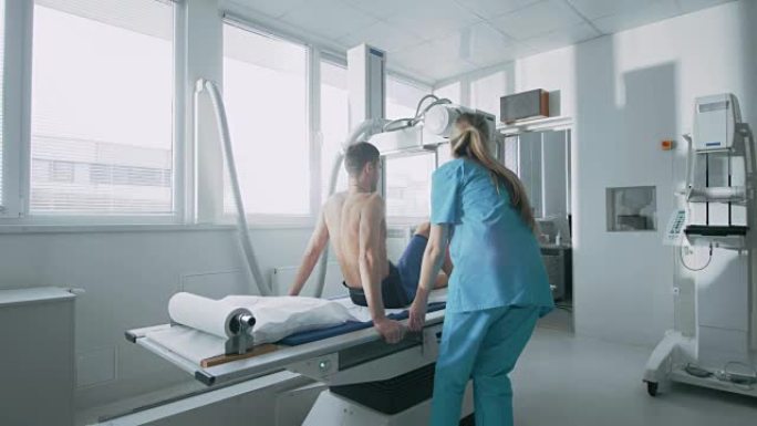 在医院里，男人坐在床上，女技术员调整x光机扫描他的腿是否受伤。扫描骨折，四肢骨折，损伤，癌症或肿瘤。