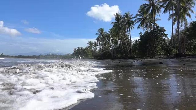 慢动作: 巴厘岛的泡沫海浪，空旷的热带沙滩和棕榈树
