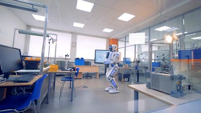 一个半机械人站在工程实验室中间不动