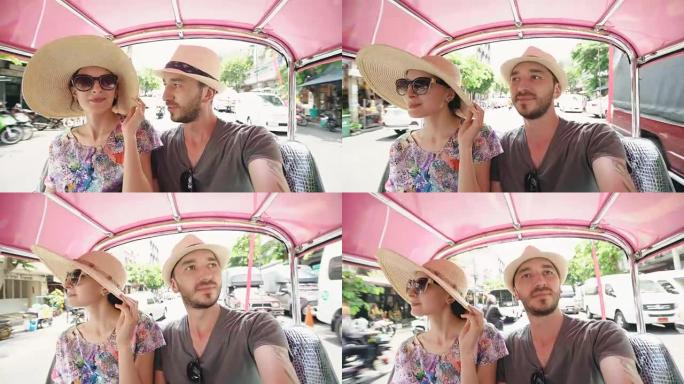 年轻英俊的男人和他的女朋友骑着传统的泰国公共汽车松托。夫妻在蜜月期间旅行泰国