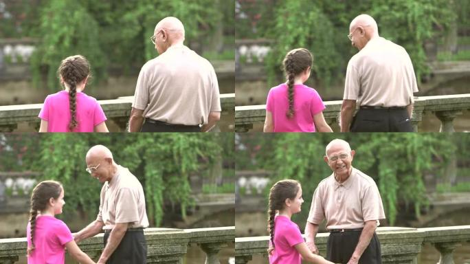 小女孩和曾祖父在公园散步