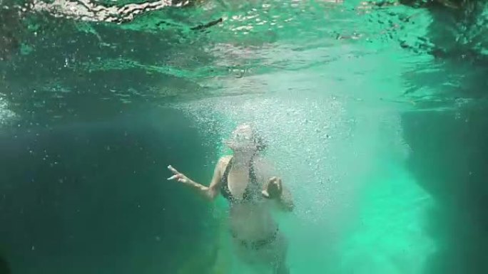 水下: 女人在翡翠河中游泳，到达空中