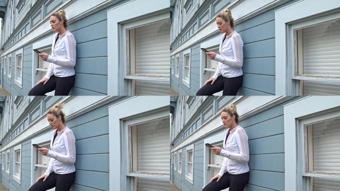 一名年轻健身女子在旧金山户外跑步后使用手机的实时视频