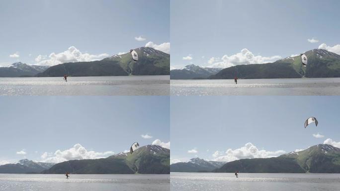 UHD 4k天线: 熟练的风筝冲浪者在阿拉斯加水域燃烧，以美丽的山脉为背景