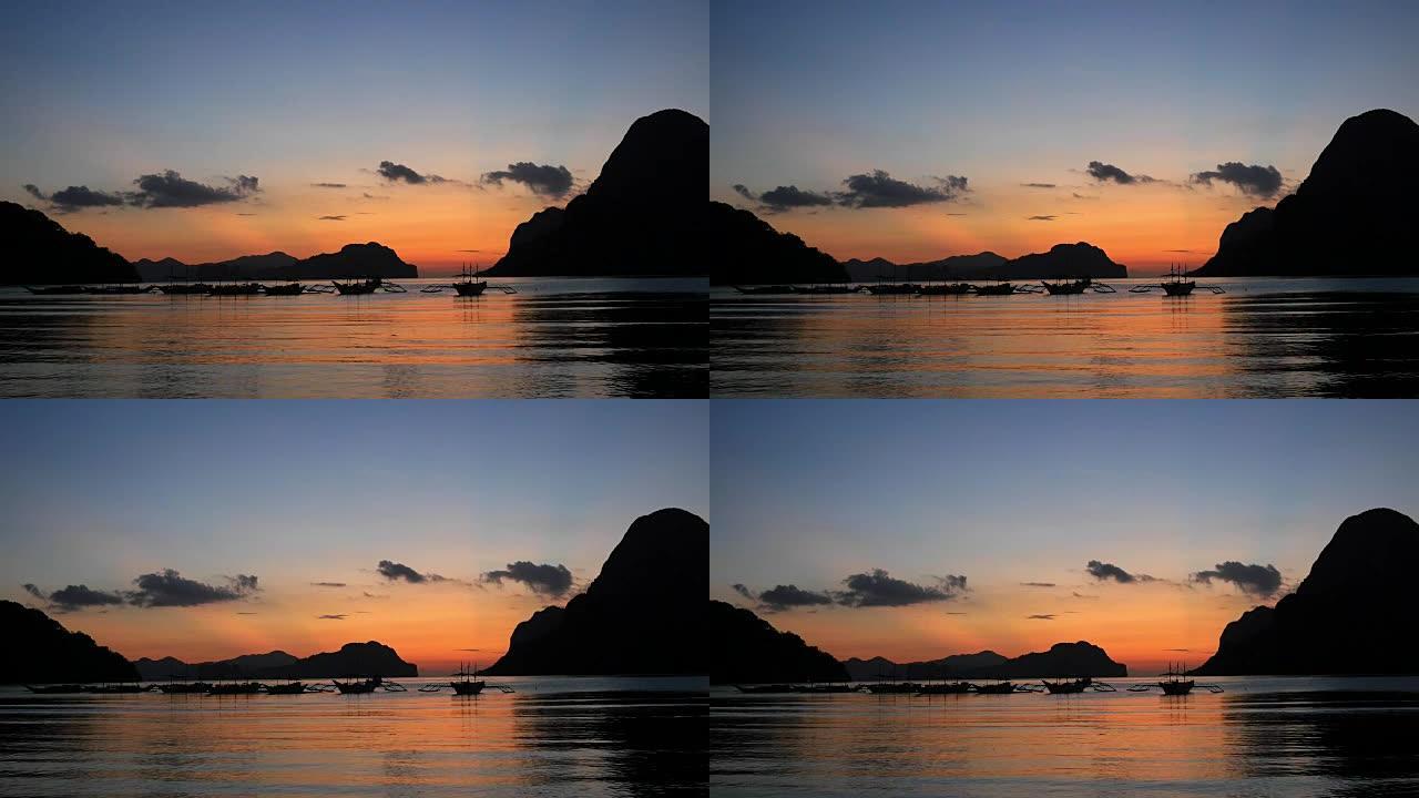 日落时带有传统菲律宾船只的热带景观。菲律宾