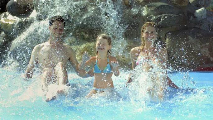 高清超慢动作: 年轻家庭在游泳池里泼水