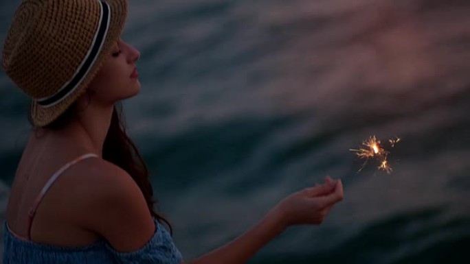 暑假的年轻女子在海上举行烟火