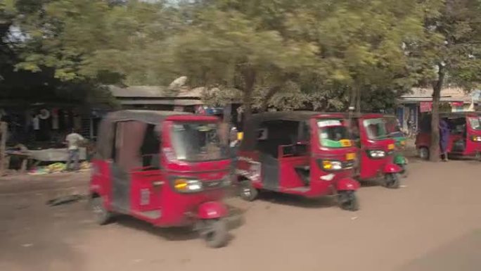 特写: 五颜六色的空嘟嘟车停在非洲城市肮脏的街道上
