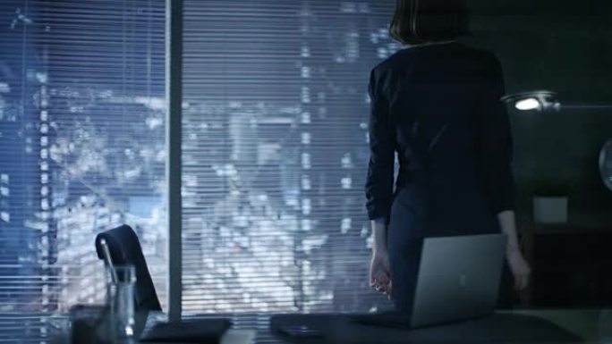 在私人办公室时尚的女商人从她的办公桌上站起来，看着窗外的大城市。