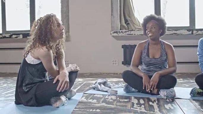 年轻女性在瑜伽课上聊天