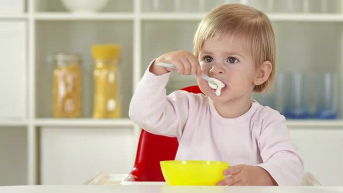 高清: 可爱的女婴独自用勺子吃饭