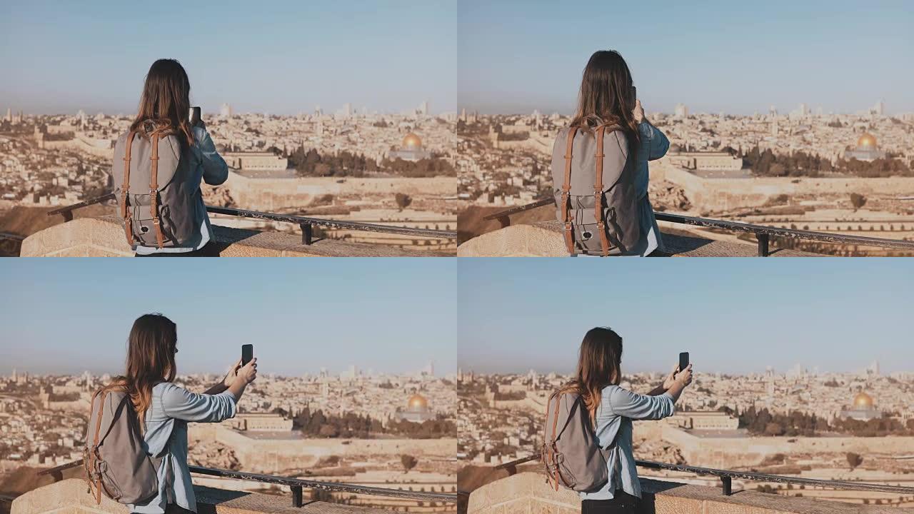 旅游女孩拍摄耶路撒冷老城的照片。背着背包的女孩走向天空边缘。捕捉瞬间。以色列4K