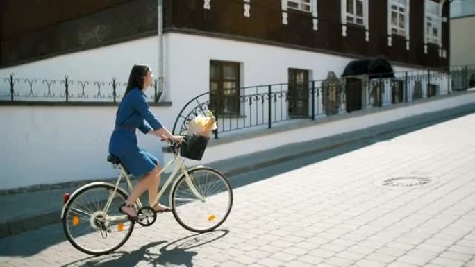 穿着裙子的快乐女孩骑自行车探索城市，慢动作，steadicam拍摄
