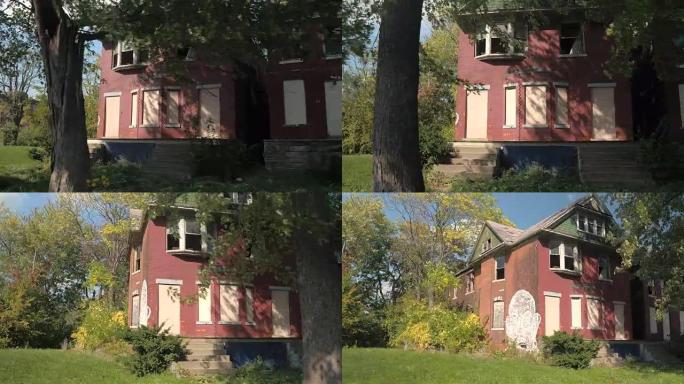 近距离观察:被茂密树叶包围的废弃腐朽房屋上的可怕涂鸦