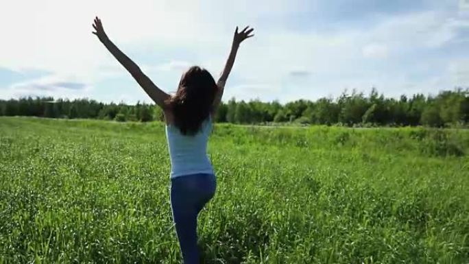 快乐美丽的女人在田野里的草地上