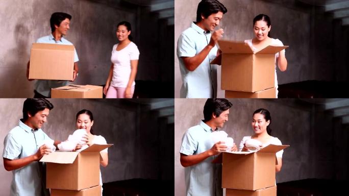年轻的亚洲夫妇打开移动箱子的包装