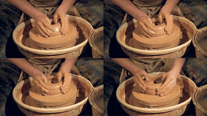 陶艺家的手在轮子上做一个宽而低的碗。