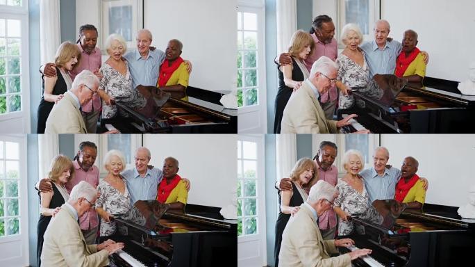 一群前辈站在钢琴旁一起唱歌