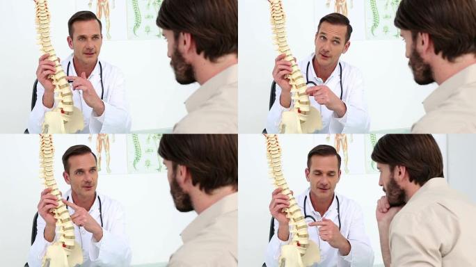 医生给他的病人看脊椎模型
