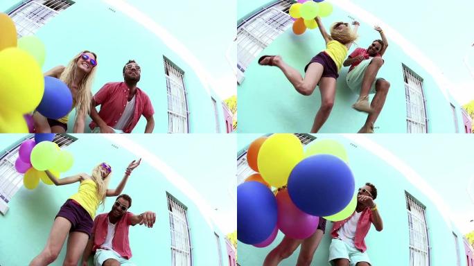 兴奋的情侣带着气球跳跃