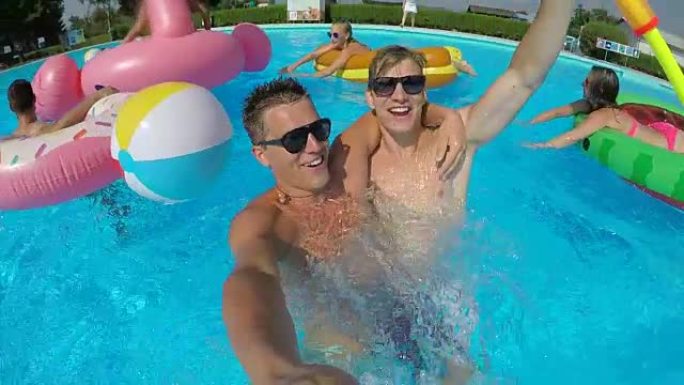 自拍照: 两个有趣的男性朋友笑着跳，在泳池派对上爆炸