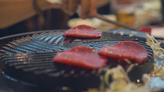 在炉子上烧烤的烧烤。关闭日本餐厅烤牛肉。烧烤或日式食品用生牛肉片