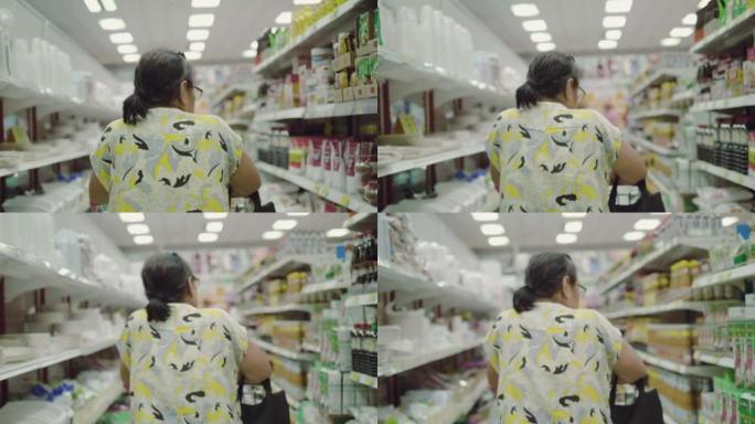 在超市使用智能手机的亚洲高级女性