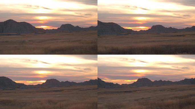 在荒地日落时，令人惊叹的尖尖砂岩山脉在干燥的草原上升起