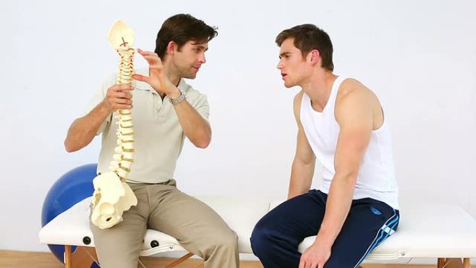 物理治疗师向患者展示脊椎模型