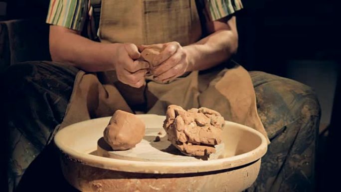 陶工手在几大块粗粘土上工作。