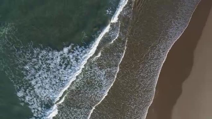 空中缩小海浪撞击海岸的圆形视图