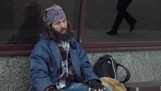 一个醉酒的无家可归者坐在街上