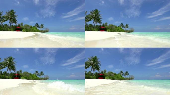 马尔代夫异国情调的白色海滩上有遮阳的红色躺椅