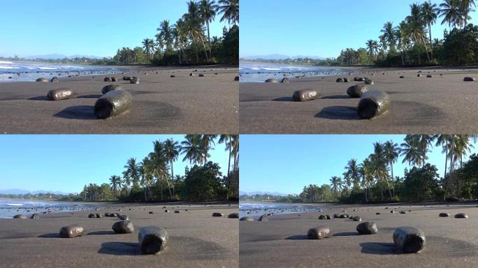 关闭热带岛华丽波光粼粼的沙滩上的黑色火山岩