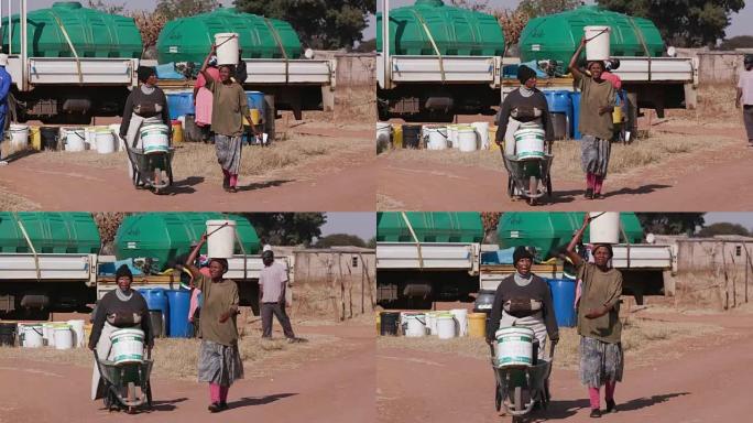 两名非洲妇女用塑料桶从一艘油轮上取水，然后走回自己的家