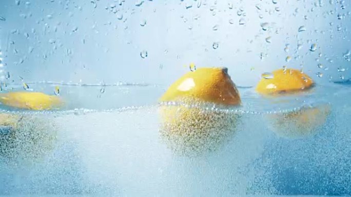 三个新鲜柠檬依次落入水中。