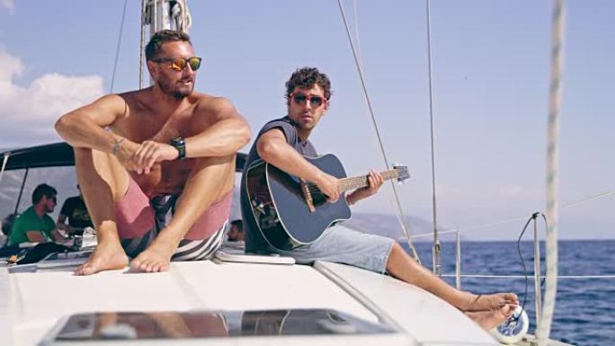 男性朋友放松，在阳光帆船上弹吉他，实时