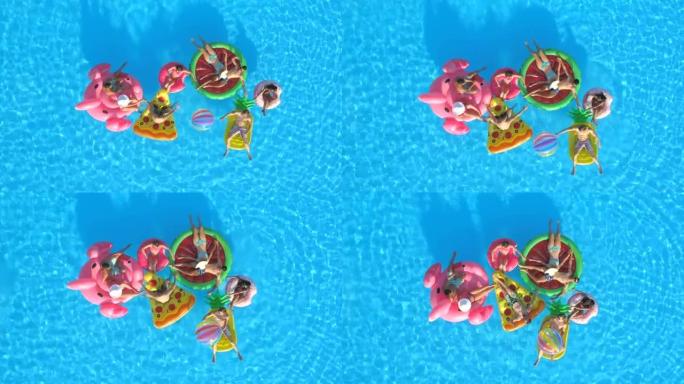 空中: 微笑的人在游泳池中有趣的充气漂浮物上玩球